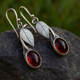 Nature Inspired Leaf Drop Earrings with Red Gemstone Glow