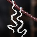 Wavy Silver Drop Earrings with Abstract Snake Energy