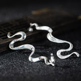 Wavy Silver Drop Earrings with Abstract Snake Energy